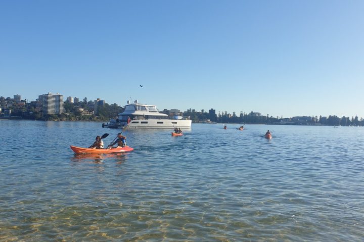 a group of people rowing a boat in a body of water