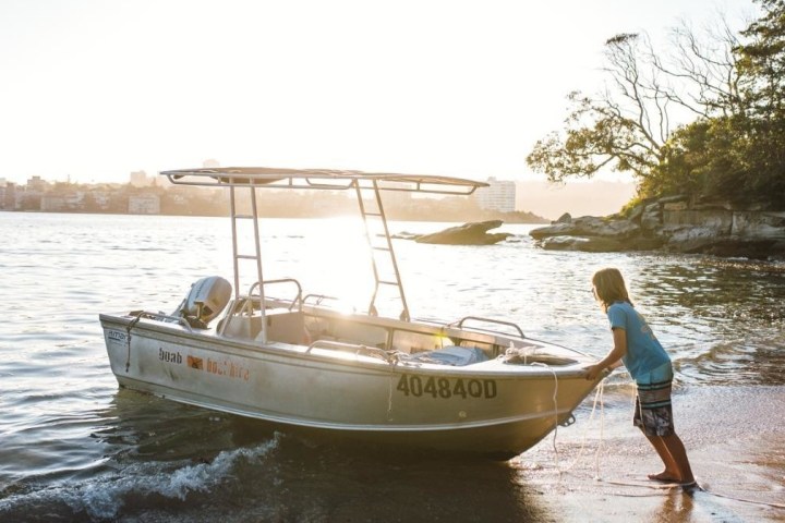 Guy pushing the boat near the shore