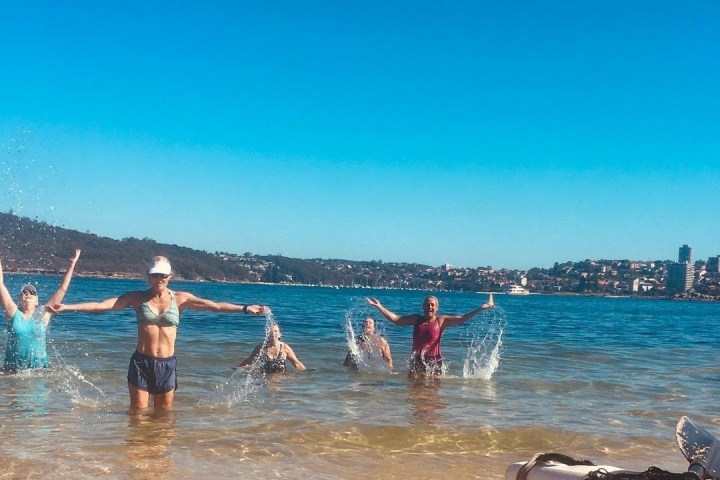 a group of people on a beach near a body of water