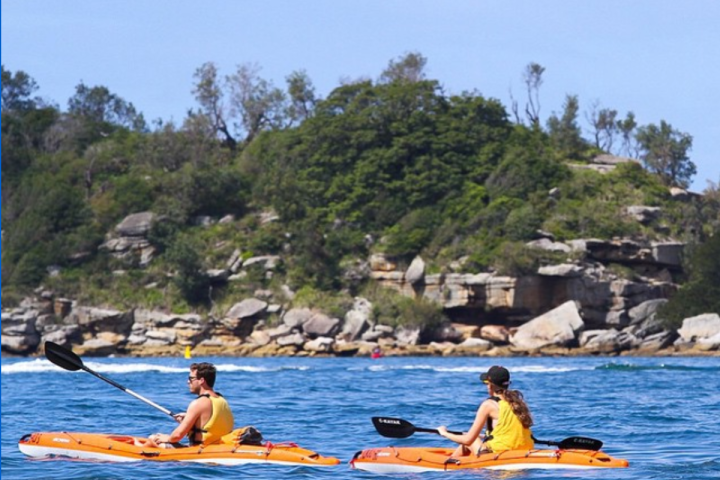 a group of people rowing a boat in the water