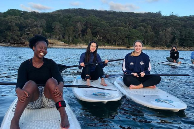 a group of people standing next to a body of water