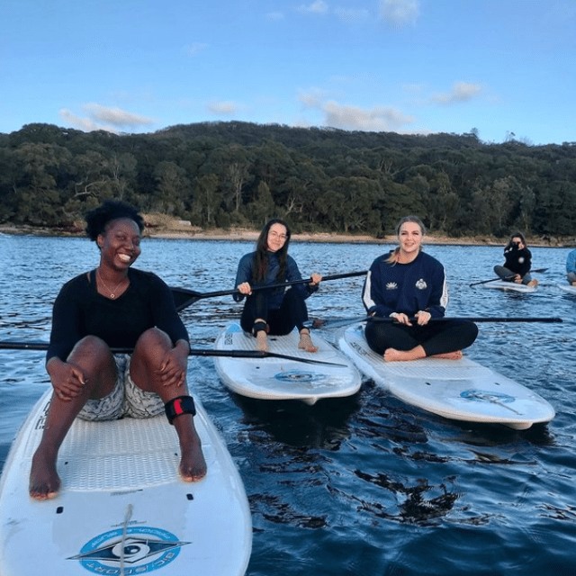 a group of people standing next to a body of water