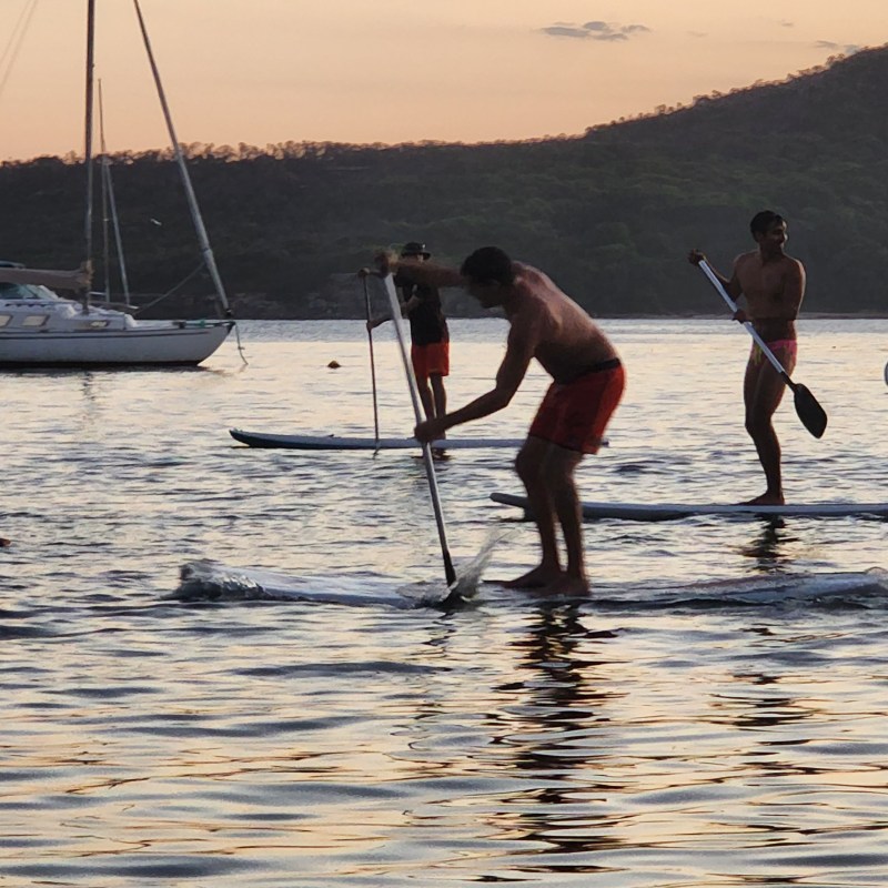 a group of people standing next to a body of water
